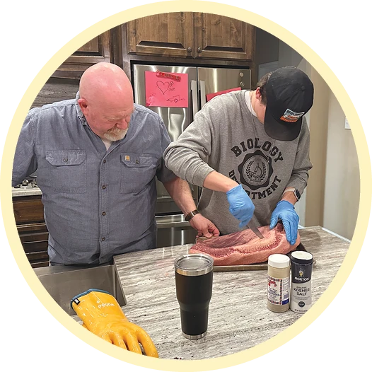 Two people work together at a table during a hands-on project.