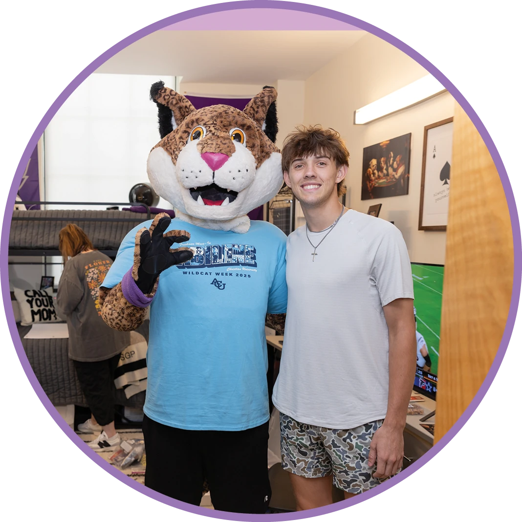 ACU student poses with Willie the Wildcat mascot.