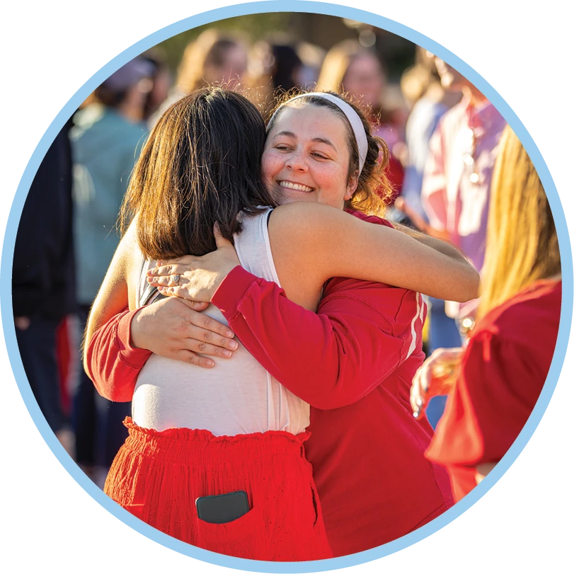 Two students hug during an ACU event.