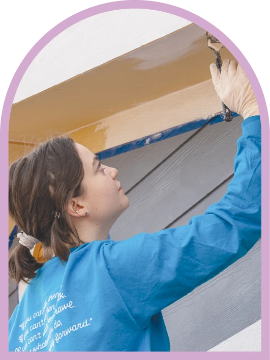 ACU student painting during a community service project.