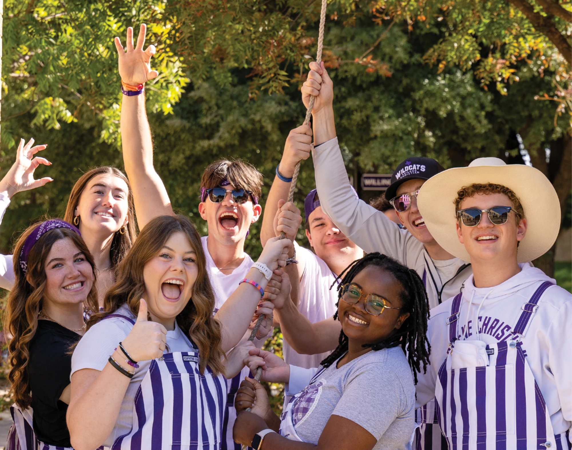 Group of ACU students cheer together outdoors.
